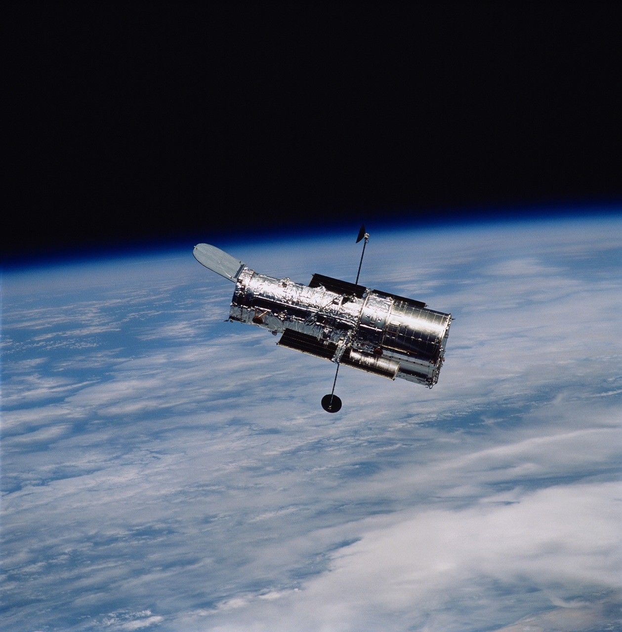 NASA photograph of the Hubble Space Telescope orbiting above Earth